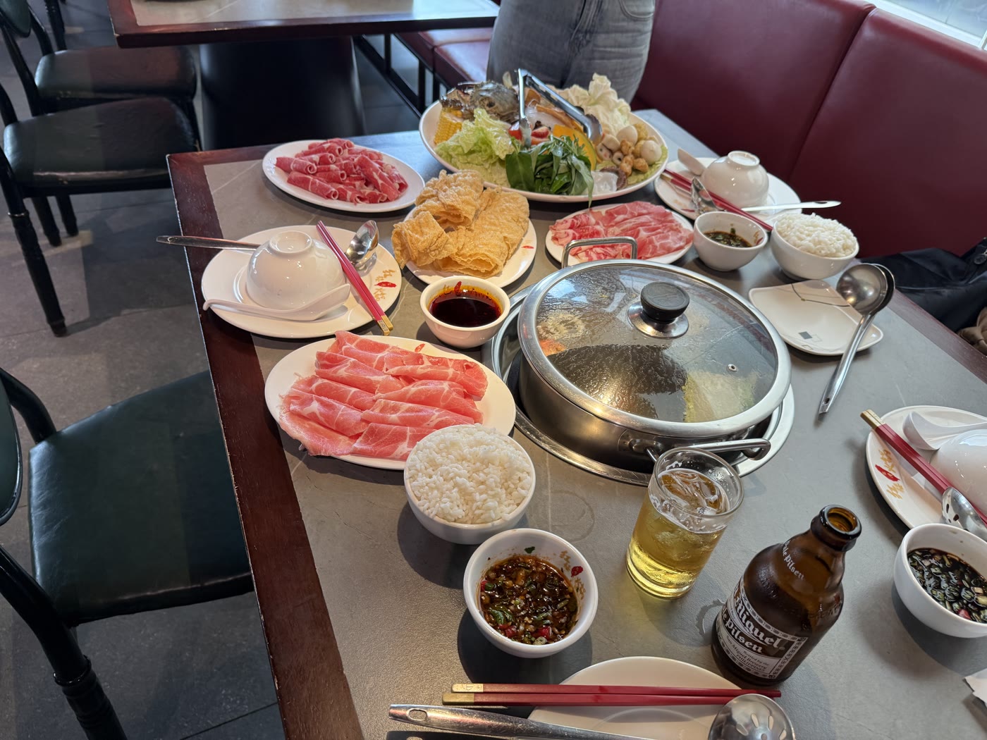 紅樓のテーブルに並んだ火鍋の具材、ラム肉・豚ロース・湯葉・ライス・サンミゲルビール