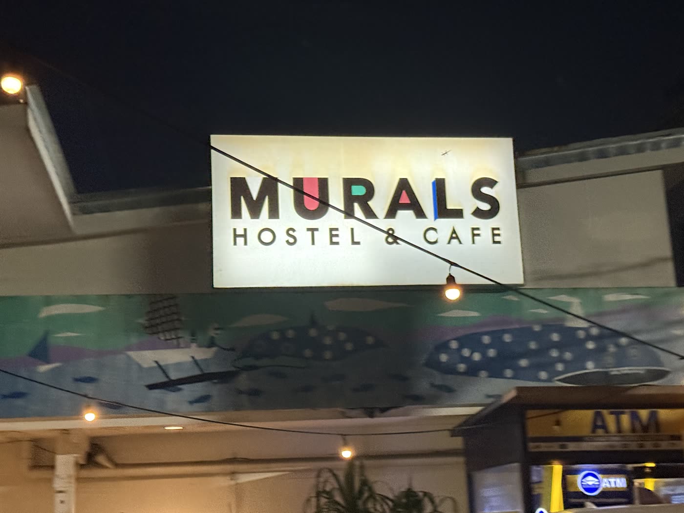 セブ市カサンバガンにあるMurals Hostel & Cafeの看板とジンベエザメの壁画